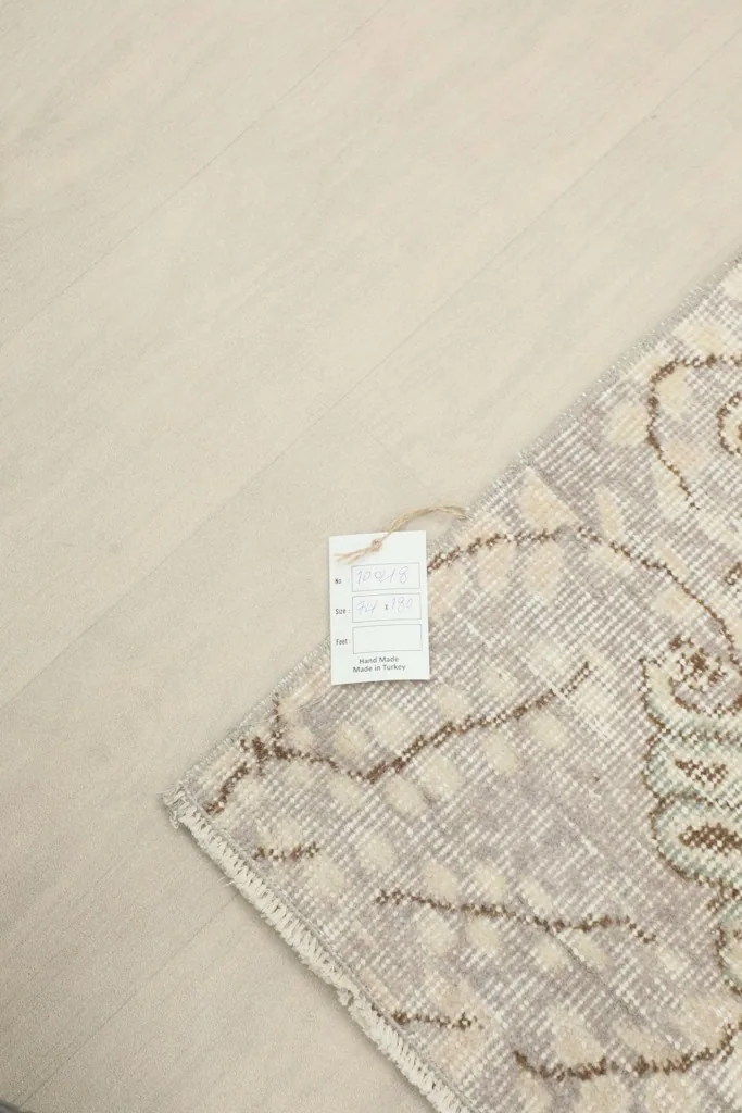 Corner of the rug with the product tag, showing the professional cleaning label and material information.
