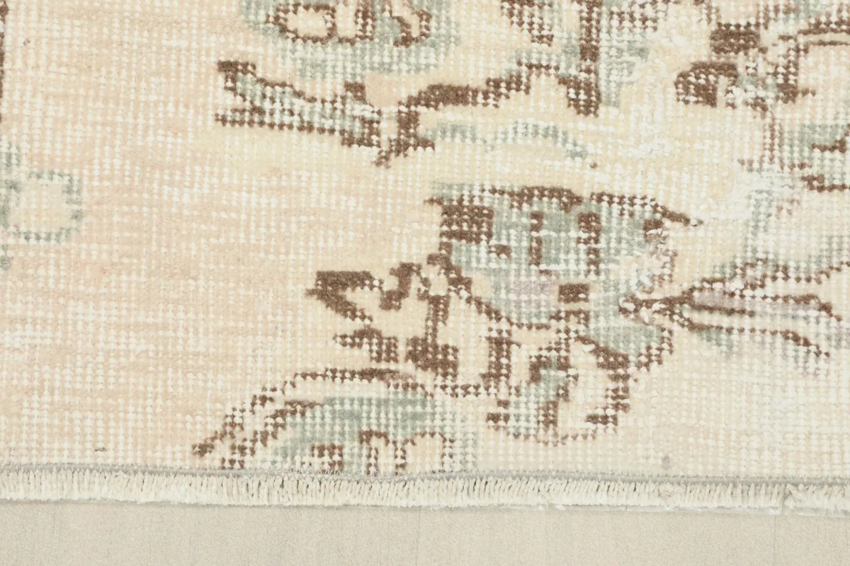 Detail shot of the rug's edge, showing the subtle border design and the short fringe.