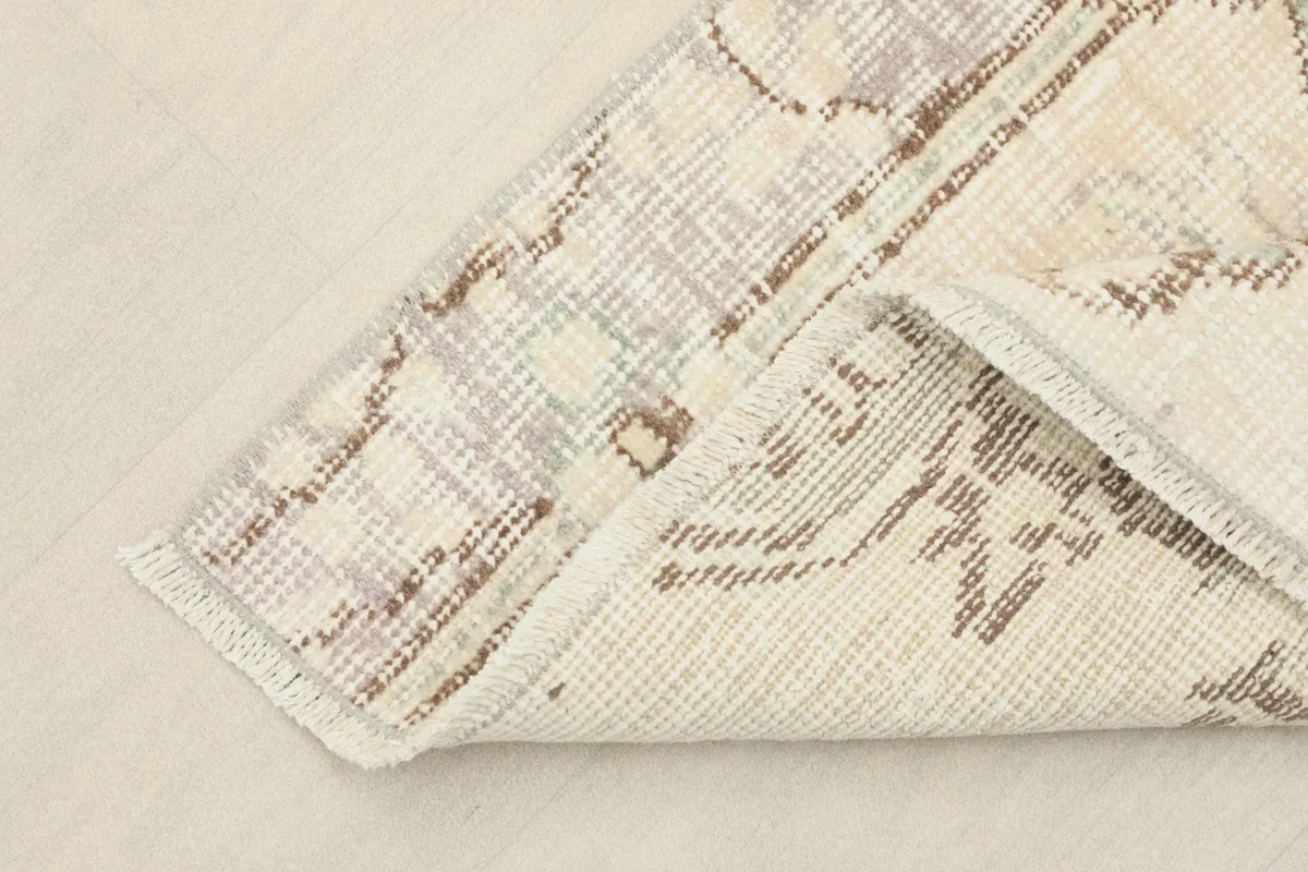 Corner of the runner folded to show the cotton foundation and reverse side of the hand-knotting.
