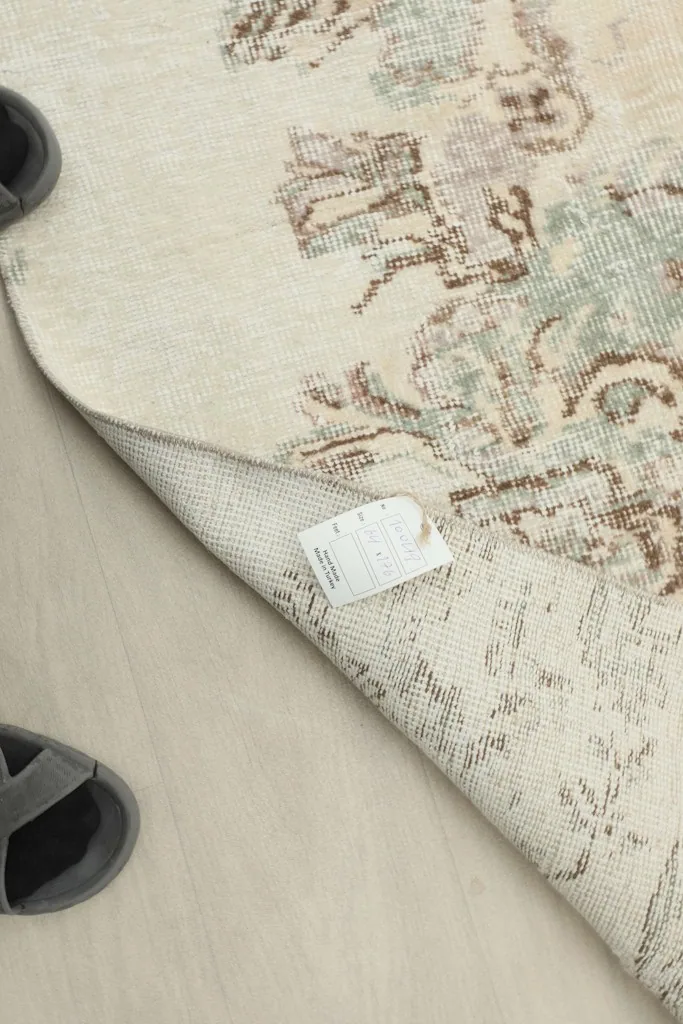 A corner of the rug with the product tag visible, showing the back of the rug.