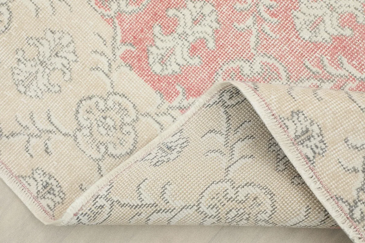 Folded corner of the rug revealing the cotton foundation and the reverse side of the hand-knotted construction.