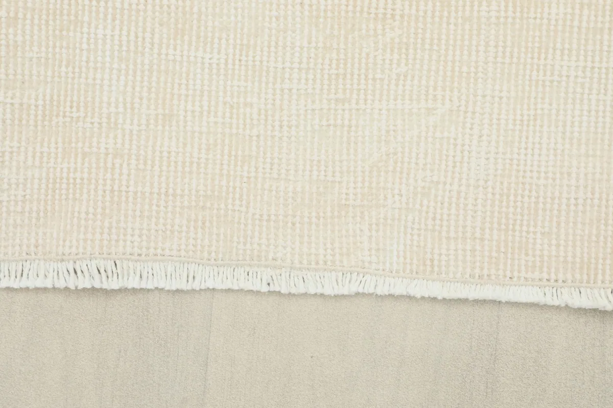 Close-up of the rug's short, natural fringe and the sturdy cotton foundation.