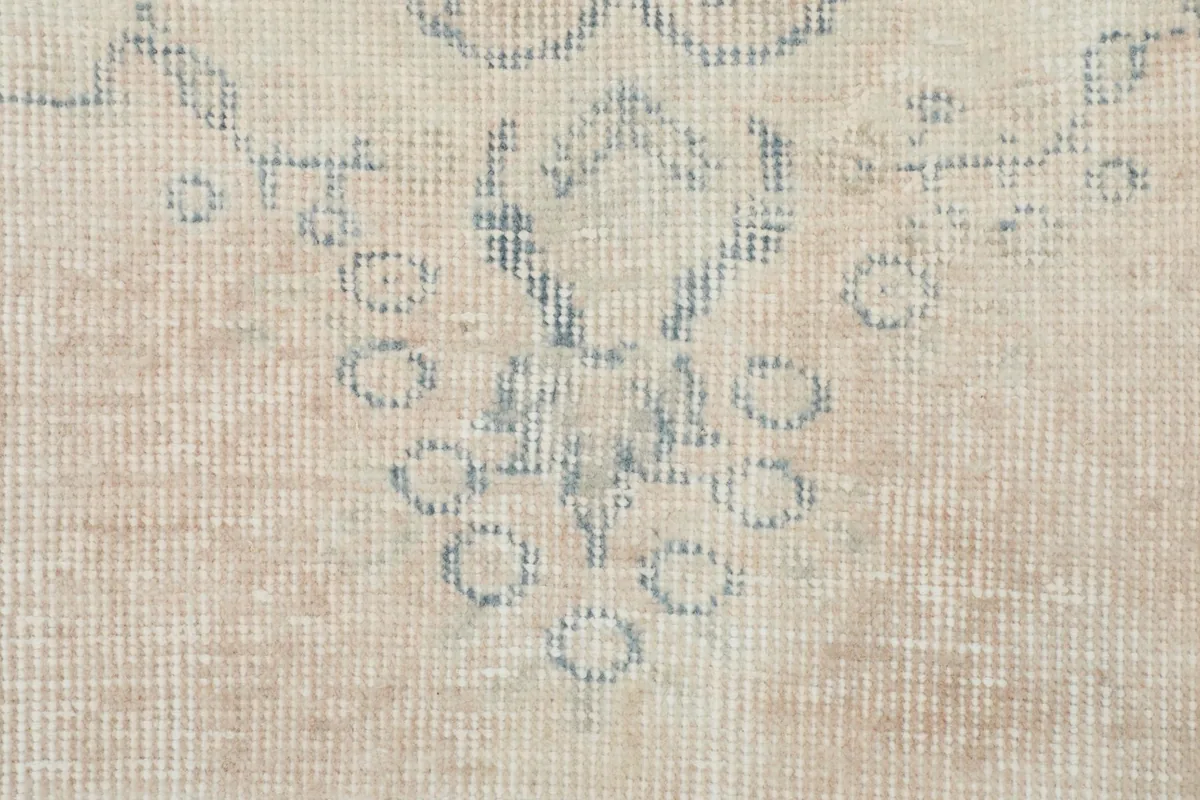 Detailed view of the hand-knotted wool pile and the intricate, worn blue patterns