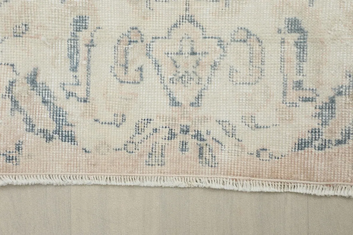 Close-up of the short, natural fringe and the border design of the vintage rug