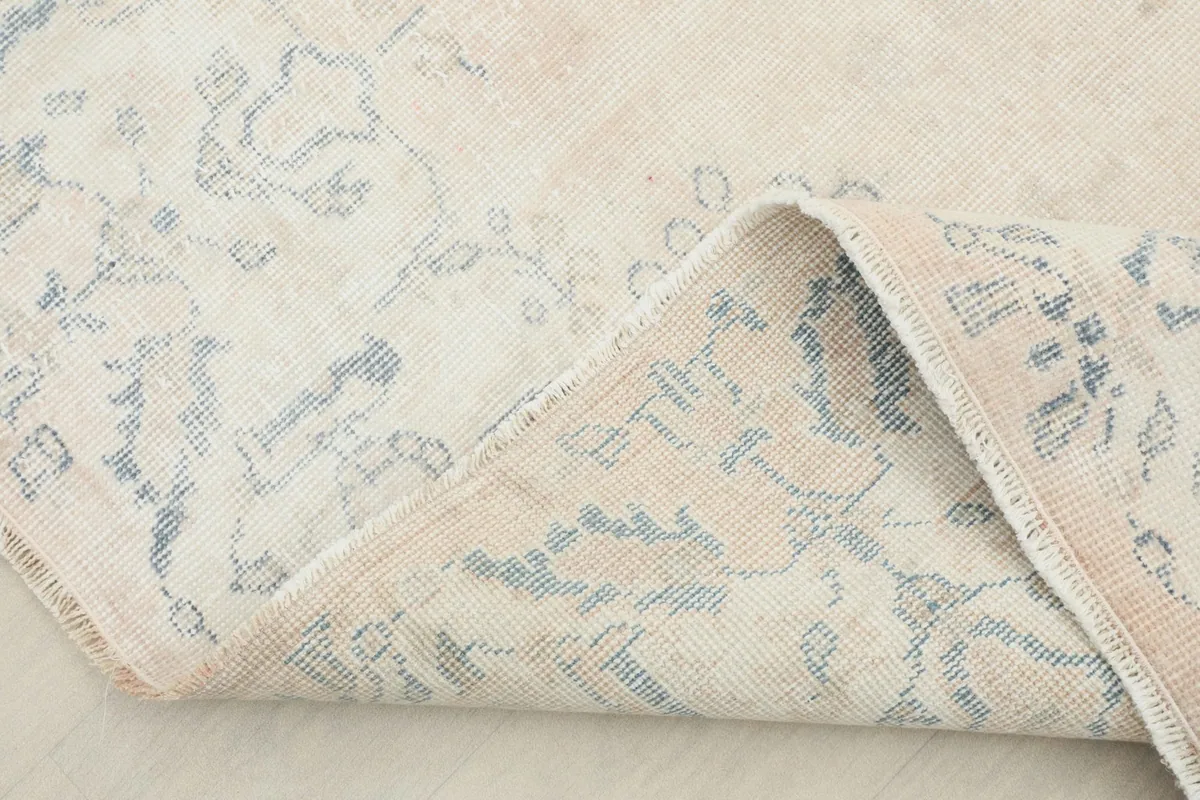 Folded corner of the rug, revealing the back of the hand-knotted cotton foundation