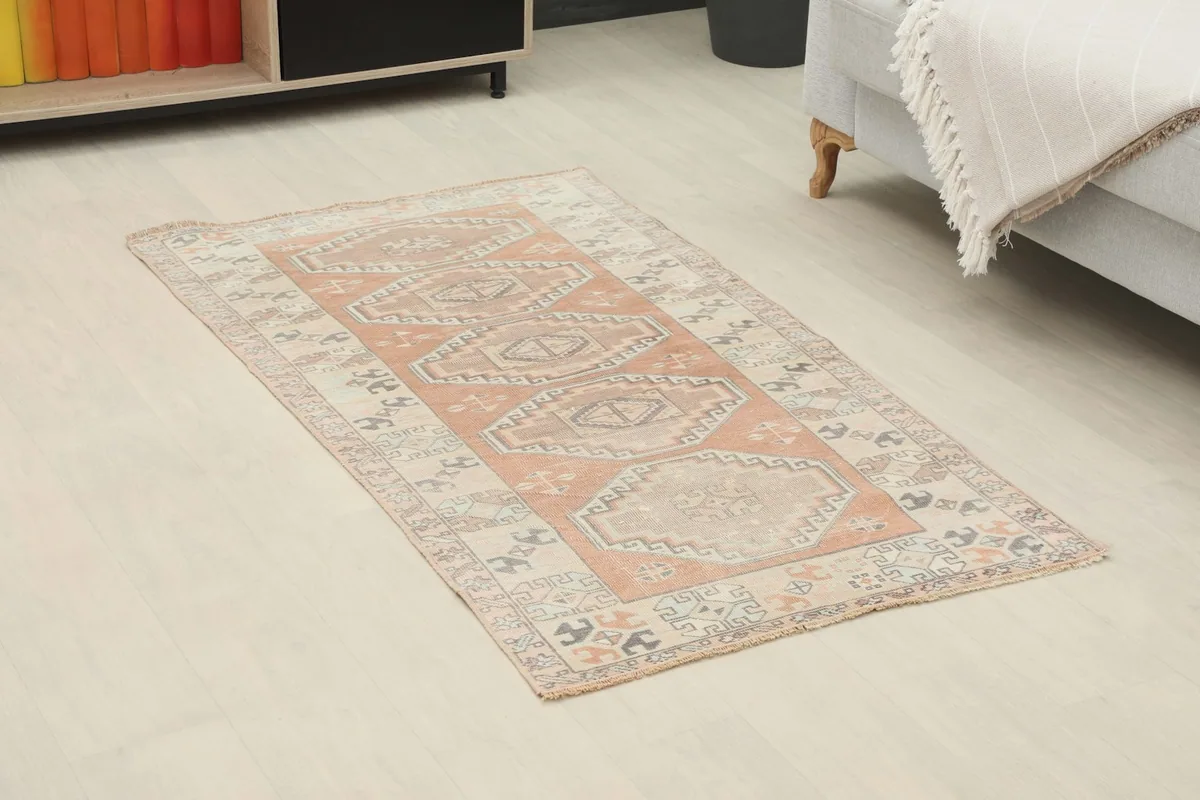 Angle view of the rust and beige geometric rug placed in a neutral room