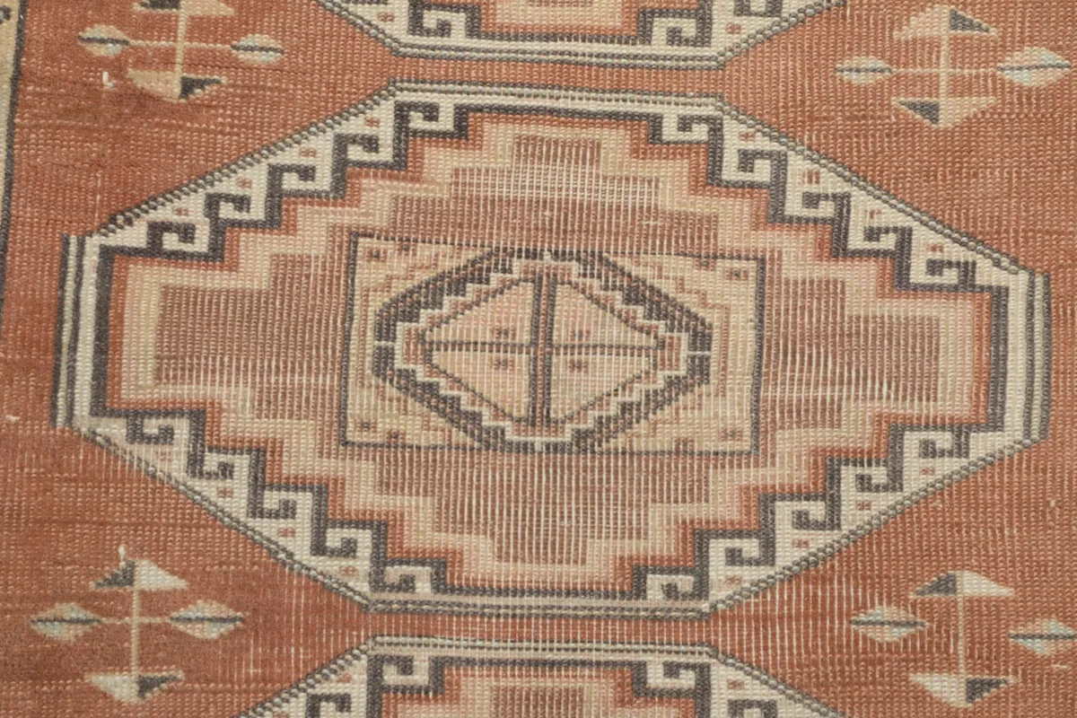 Detailed view of one central geometric medallion with charcoal and beige accents
