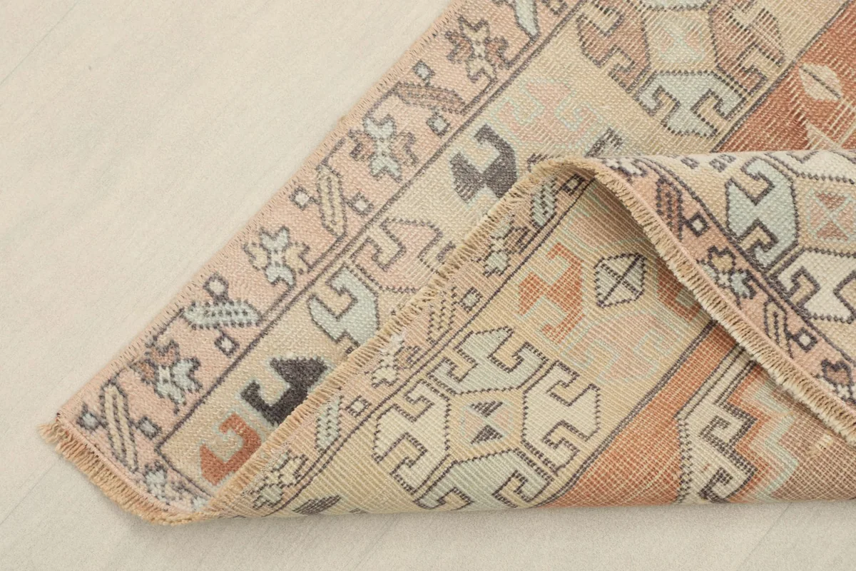 Corner of the hand-knotted rug folded to show the back and weave texture