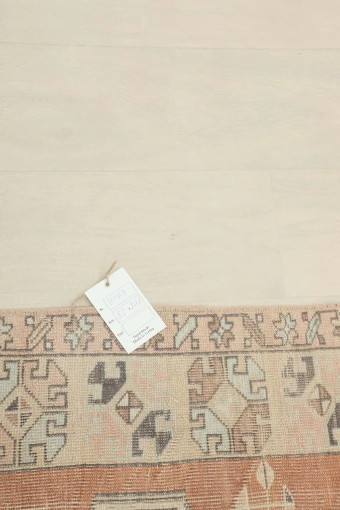 Close-up of the rug's edge with a tag, showing the detailed border patterns