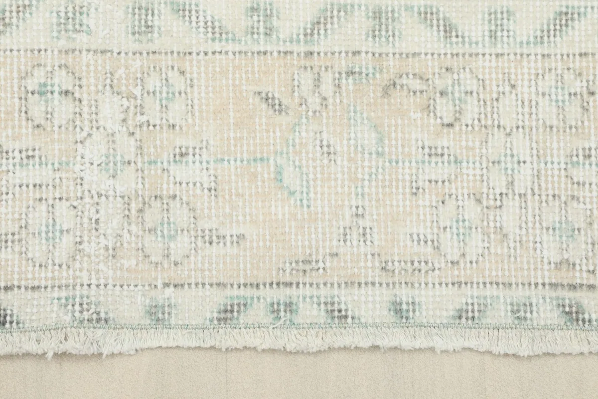 Close-up of the rug's fringe and the detailed border pattern near the edge.
