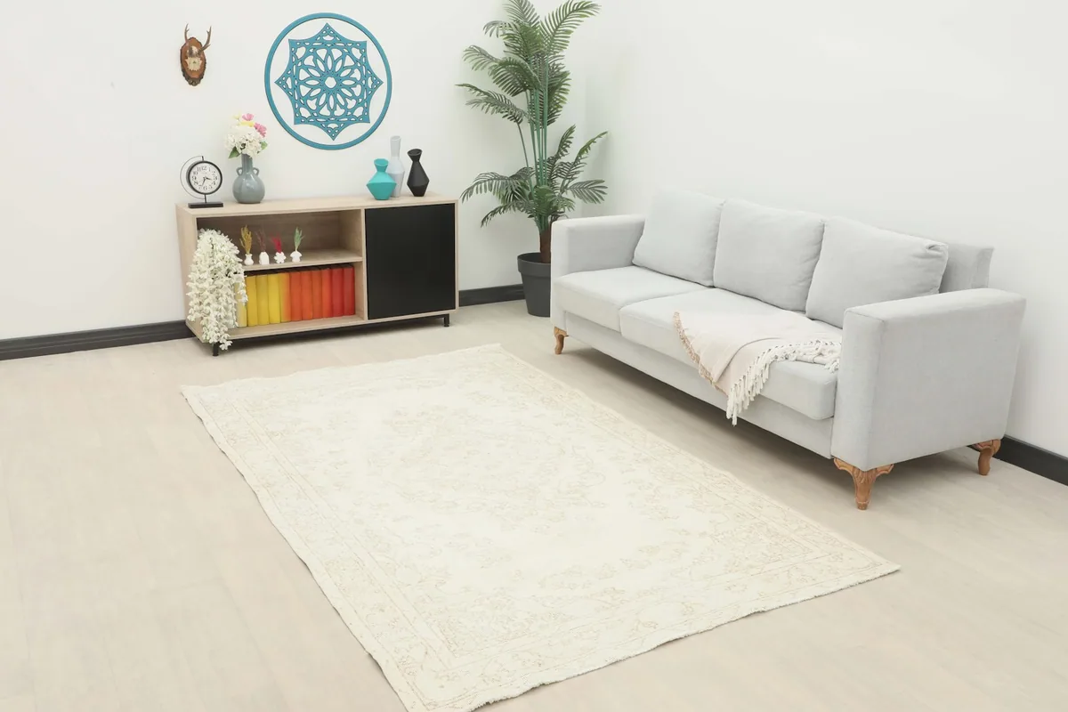Ivory tonal medallion rug placed in a living room setting with a light gray sofa and modern decor.