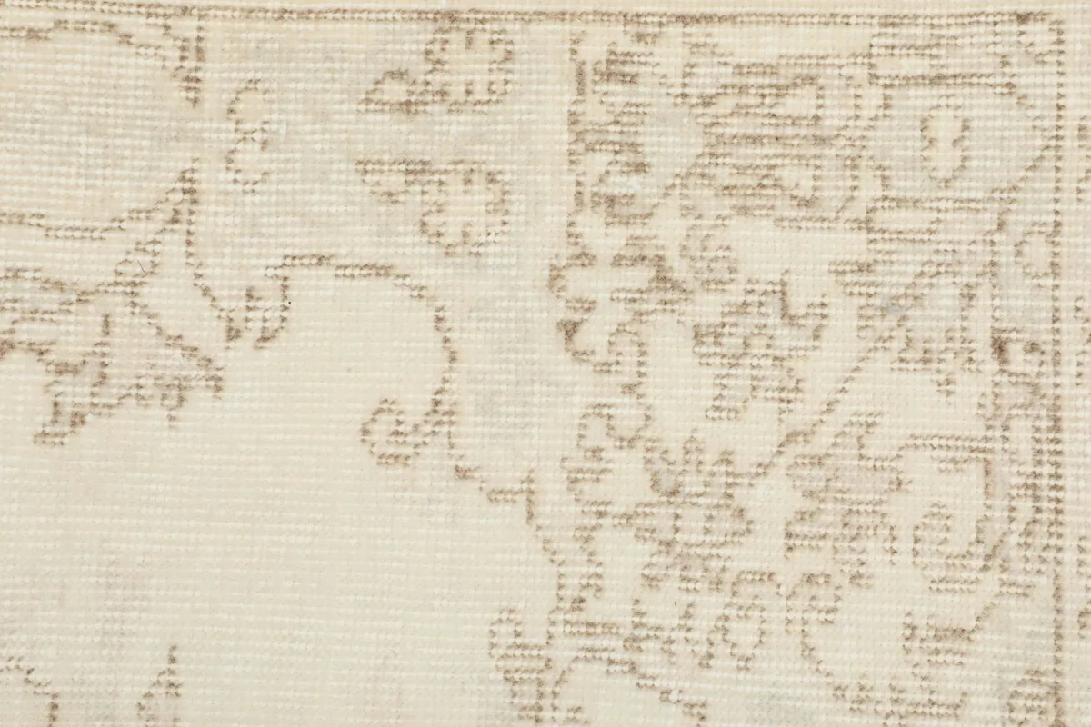 Close-up detail of the rug's border, showcasing the hand-knotted wool pile and subtle beige patterns.