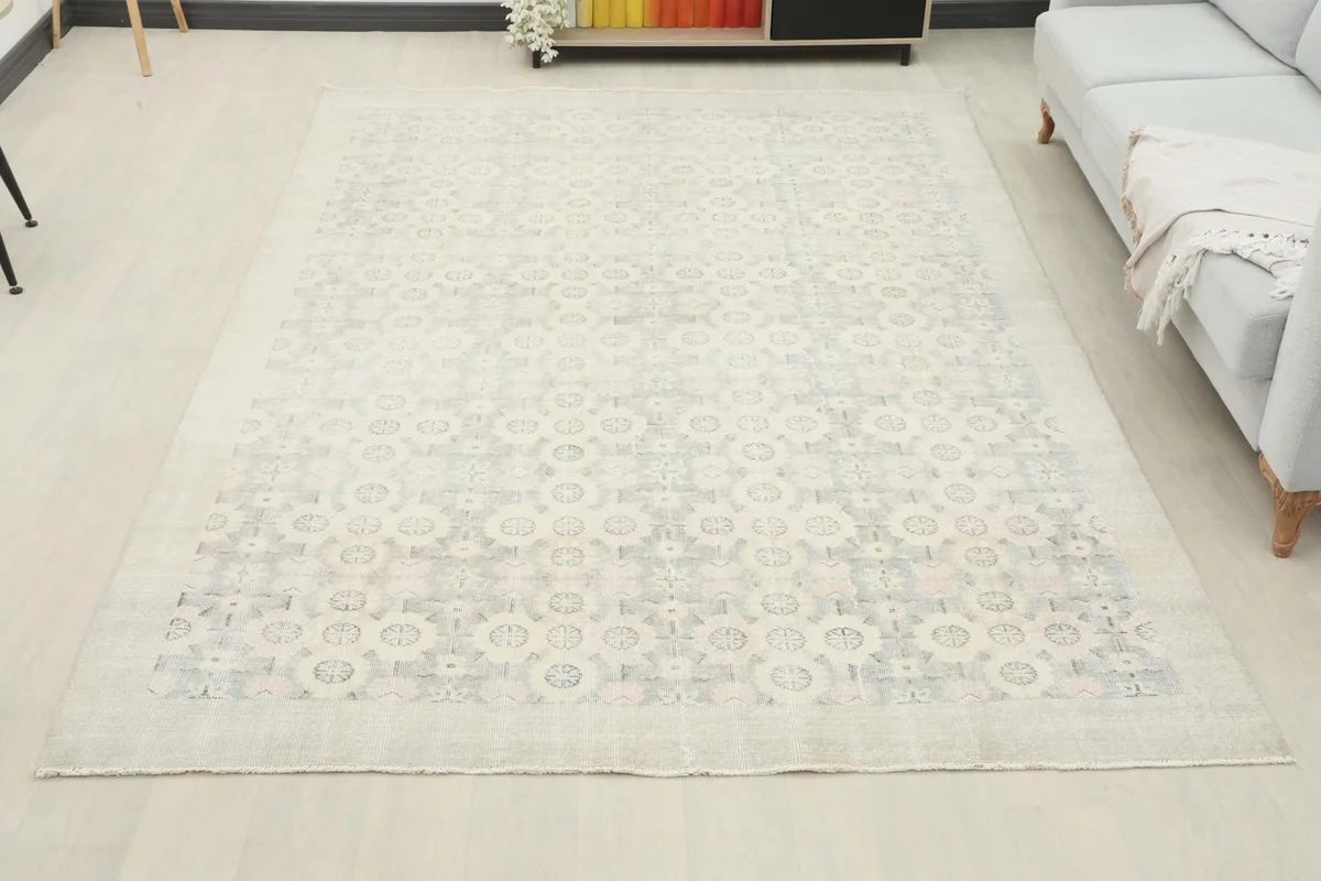 Overhead view of the large cream and gray vintage rug in a living room, providing scale.