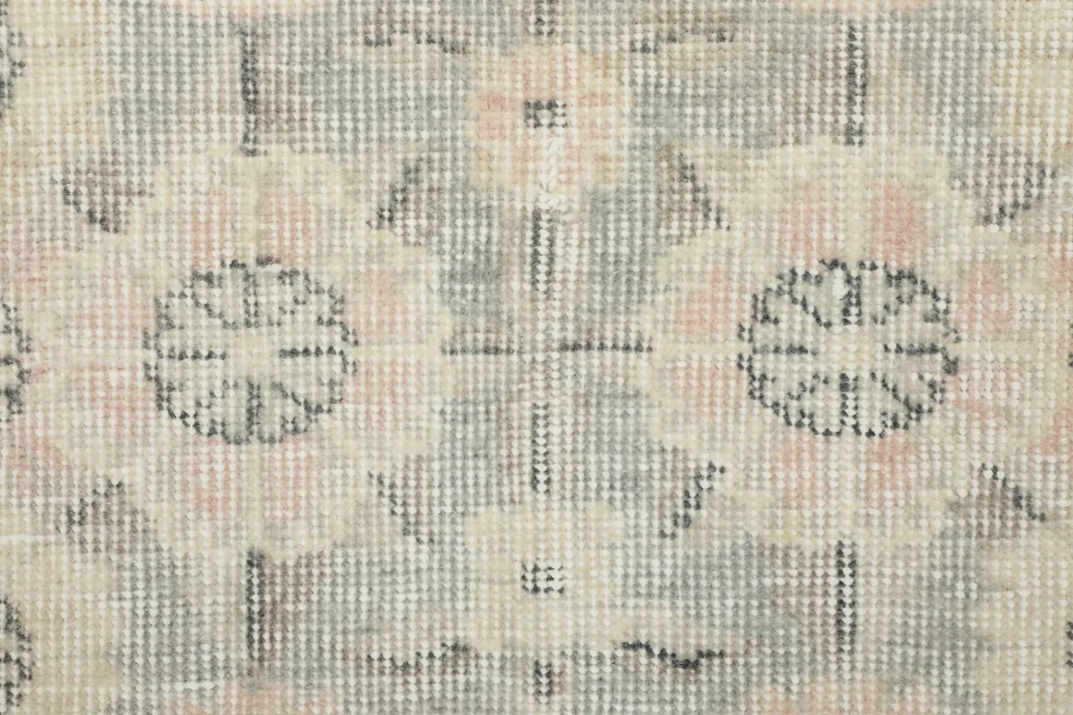 Detailed shot of the hand-knotted wool pile, showing the intricate pattern and faded colors.
