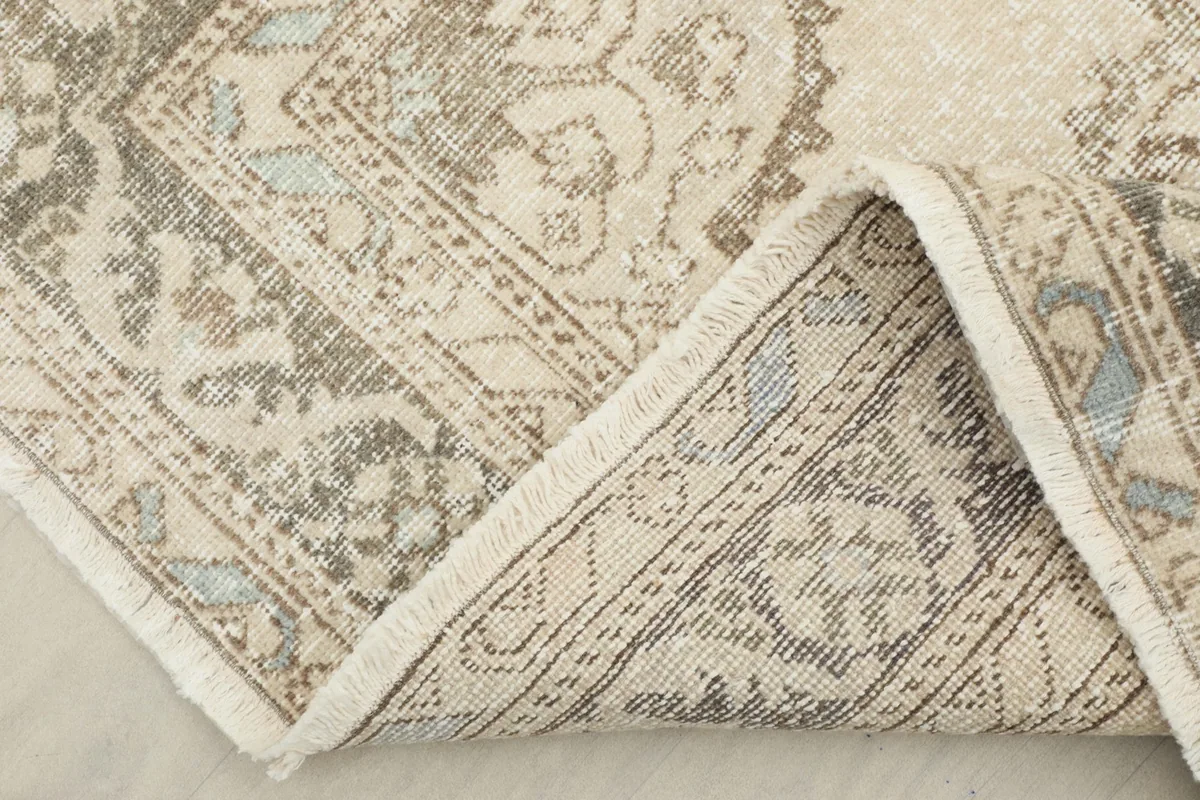 Corner of the runner folded back to show the cotton foundation and hand-knotting.