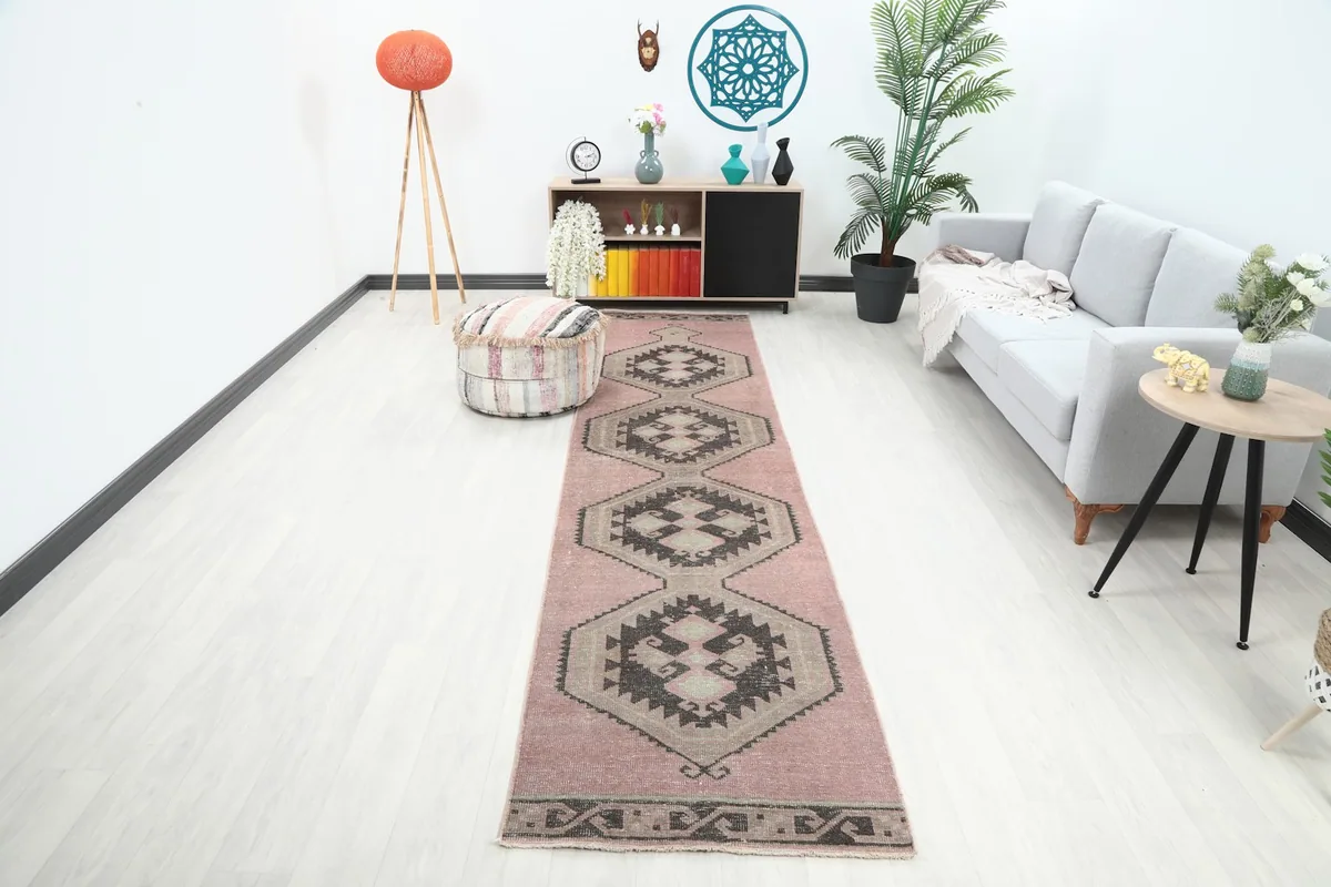 Vintage rose runner rug displayed in a living room setting with a light gray couch