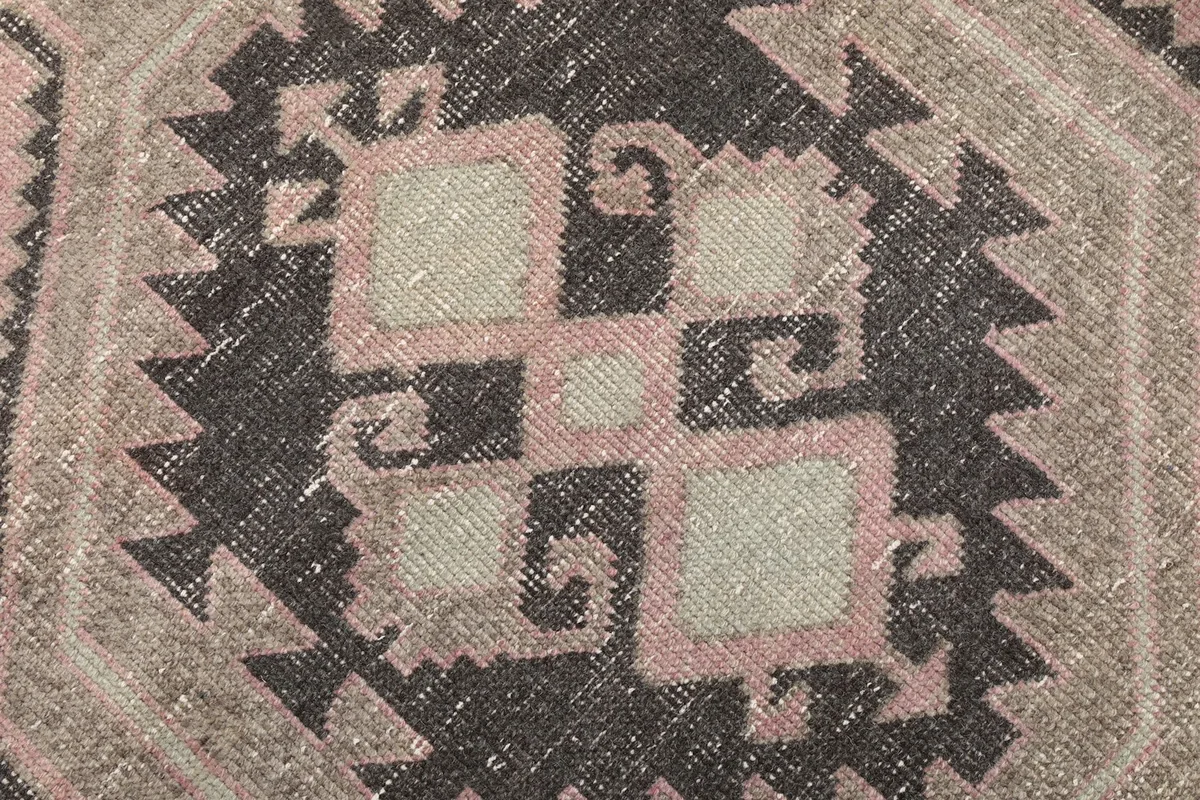 Extreme close-up of the hand-knotted wool pile and intricate geometric pattern