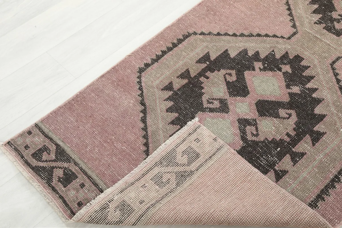 Folded corner of the runner revealing the wool pile and cotton foundation