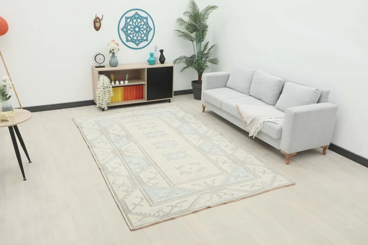 Vintage Anatolian rug with ivory and blue patterns in a modern living room setting