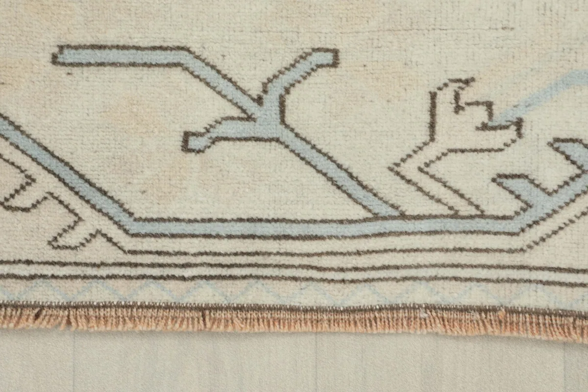 Close-up of the rug's border and fringe, showing the hand-knotted wool texture