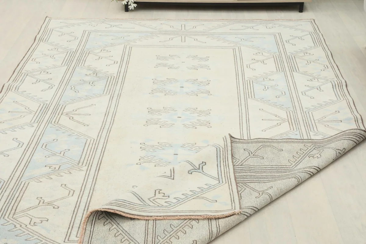 Rug partially folded to show the thickness and texture of the wool pile and cotton foundation