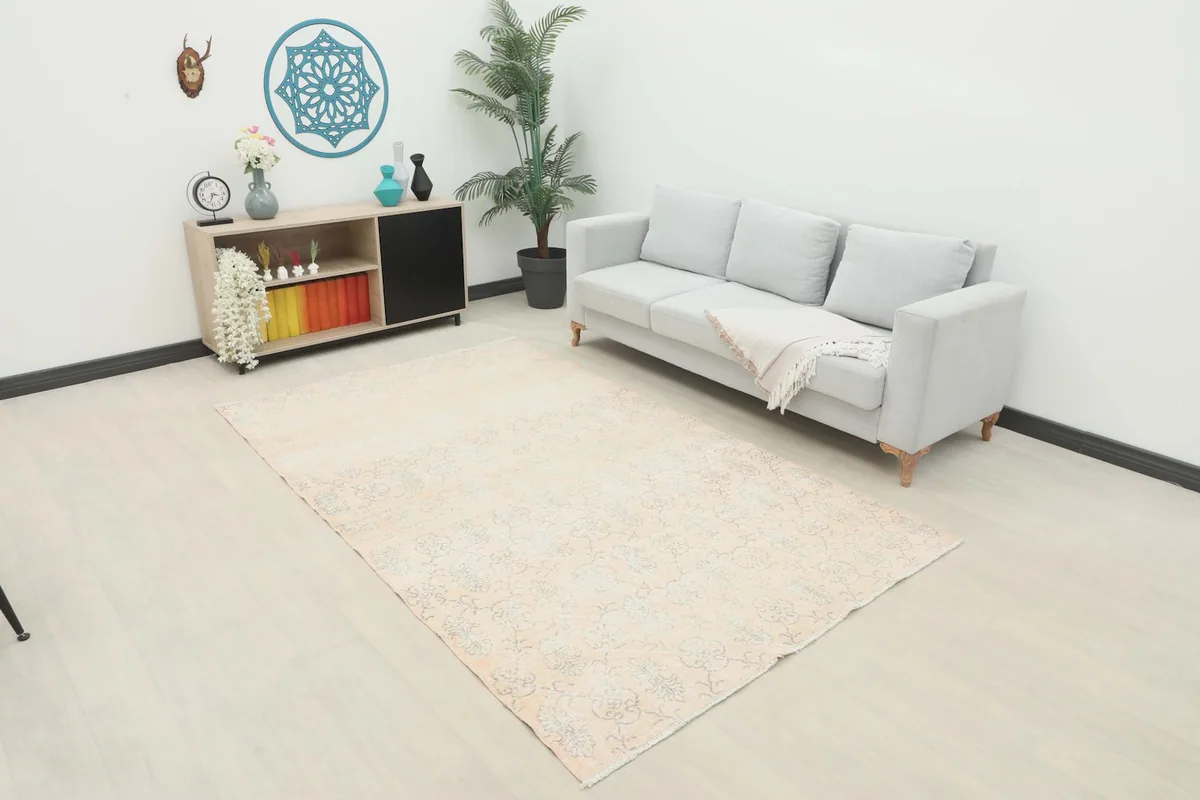 Vintage Anatolian rug in a room setting, showing its scale next to a sofa and cabinet.