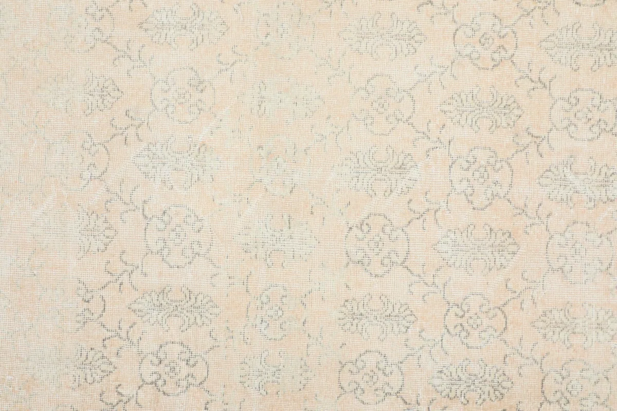 Detailed view of the rug's surface, focusing on the hand-knotted floral design and low pile.