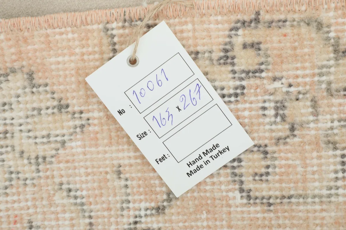 Product tag attached to the rug, displaying its unique number, size in centimeters, and 'Hand Made in Turkey'.
