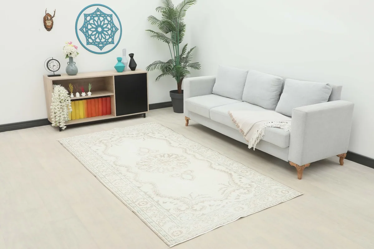 Vintage Anatolian rug displayed in a living room setting with a light gray sofa