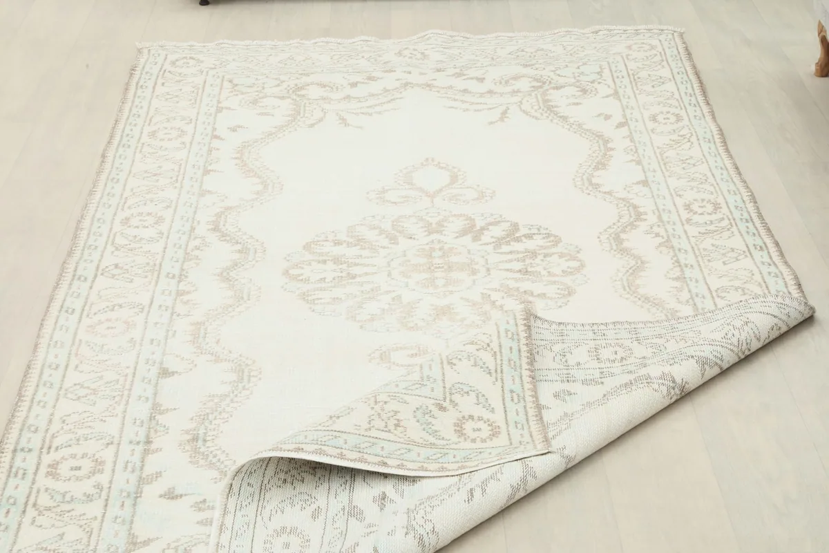 Partial view of the rug with a corner folded, showing the back and front texture