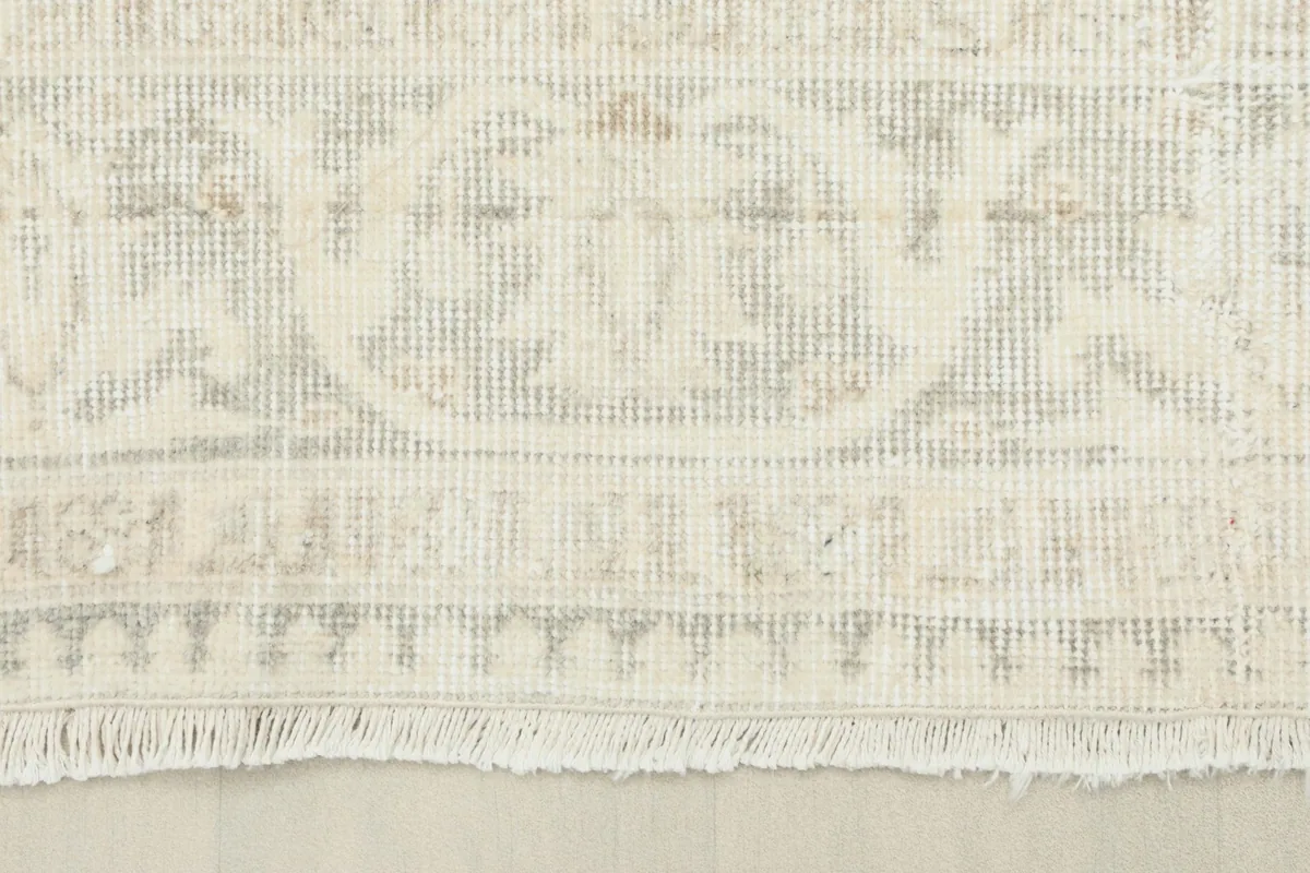 Detail of the rug's border and fringe, showing the hand-knotted construction