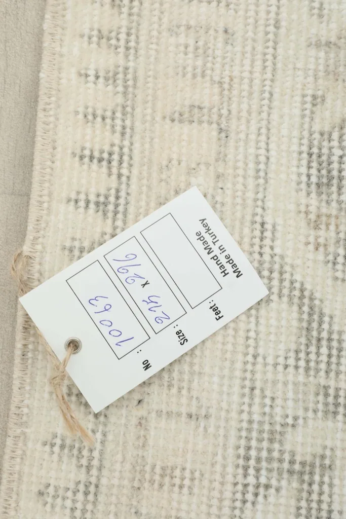 Close-up of the rug's reverse side with a size tag, showing the knotting and origin