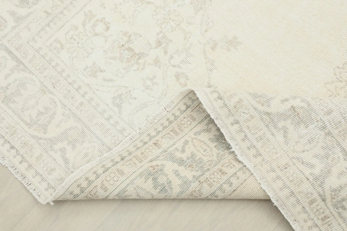 View of the rug folded back slightly, revealing the cotton foundation