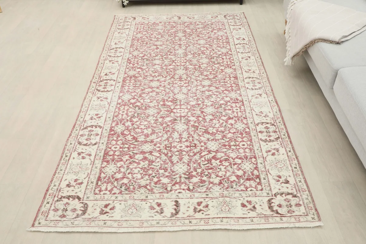Full overhead view of the rose and ivory rug in a spacious room setting, showcasing its dimensions