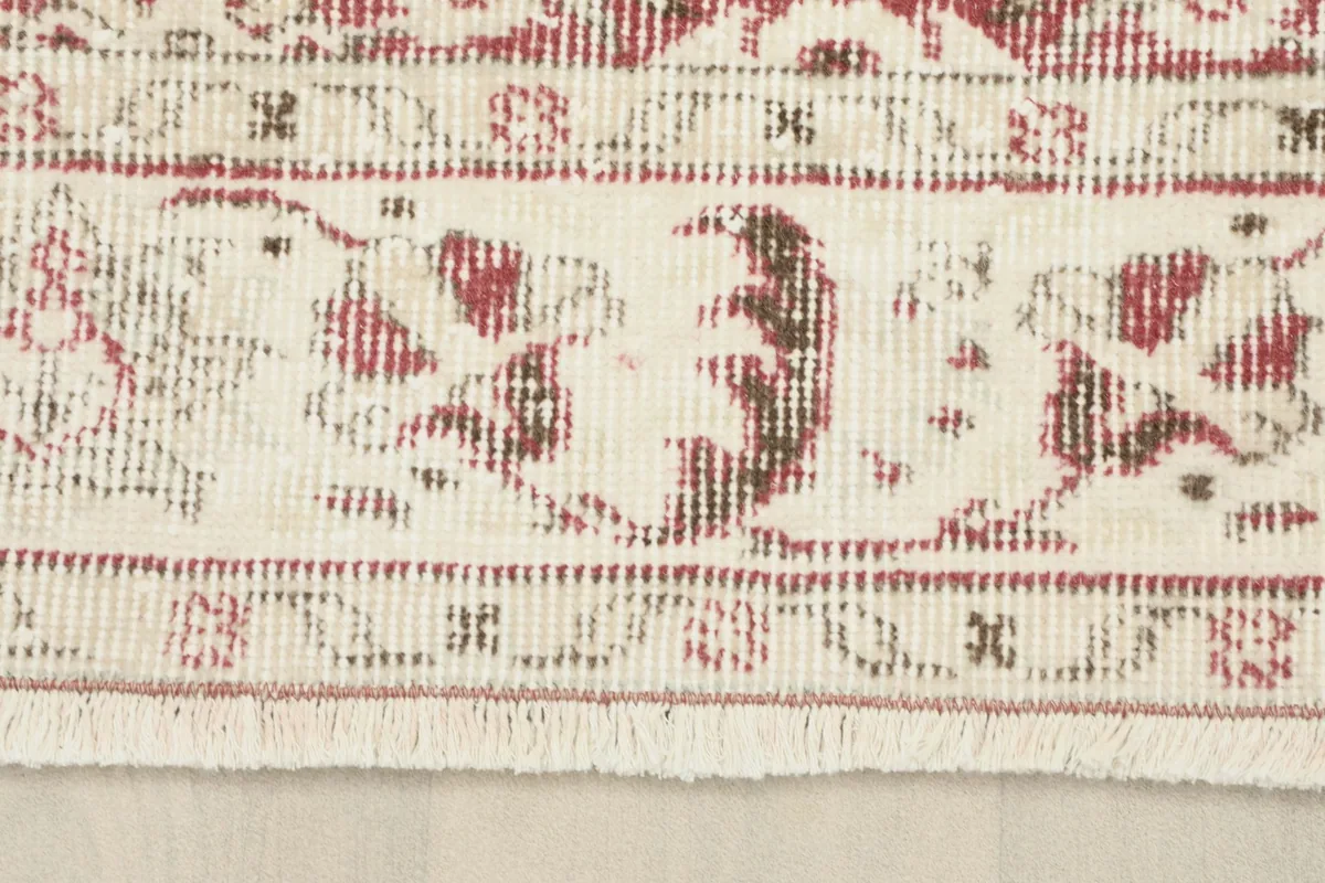 Close-up of the ivory border and short fringe on the end of the hand-knotted rug