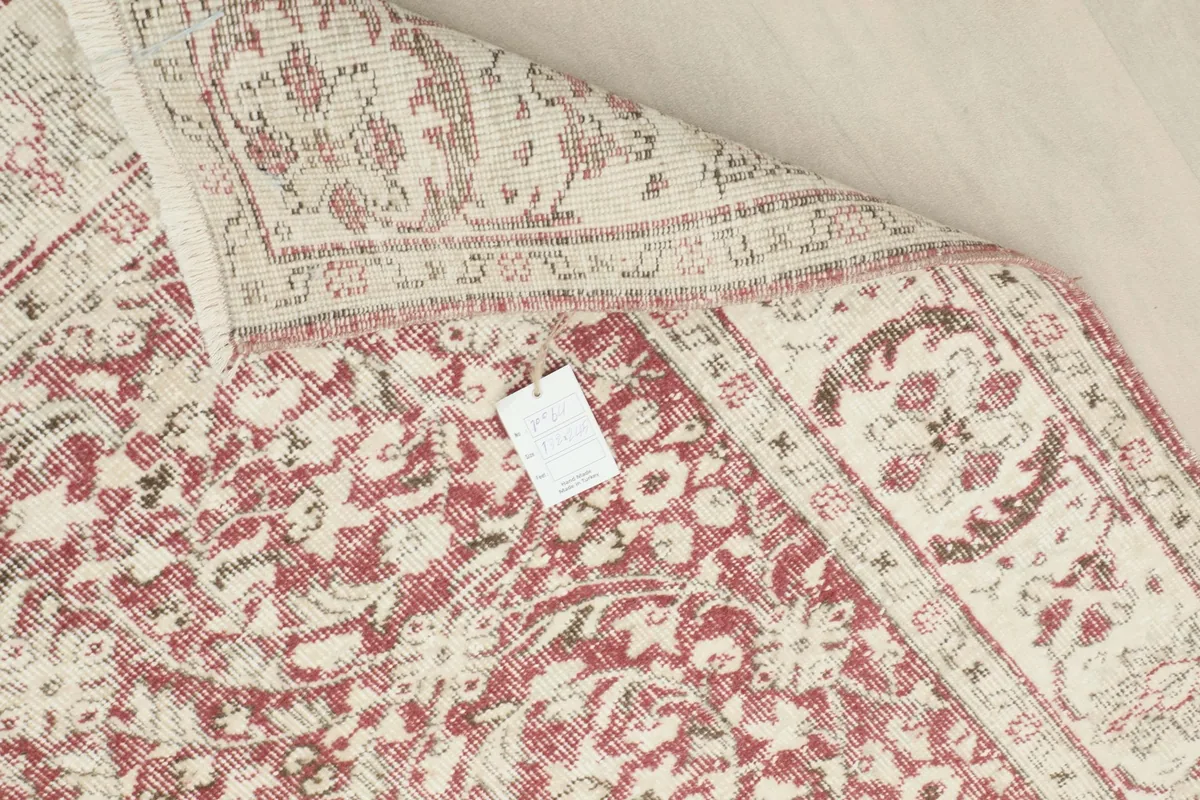 Close-up of the back of the hand-knotted rug, revealing the intricate weaving and attached tag
