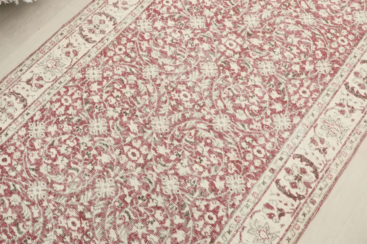 Detailed overhead view capturing the full pattern repeat across the rose field of the rug
