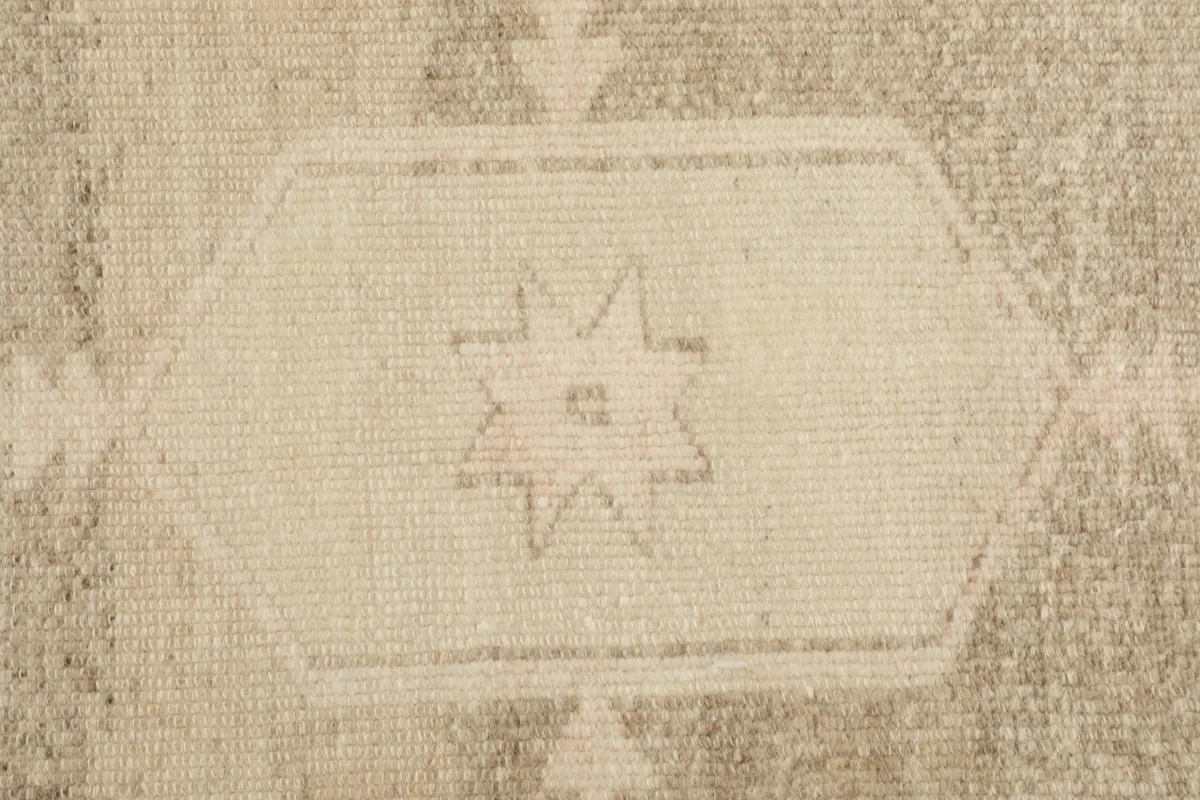 Detailed view of a star-like motif within the main geometric pattern of the rug.
