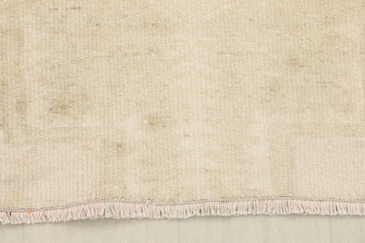 Close-up of the short, natural fringe and the edge of the vintage runner rug.