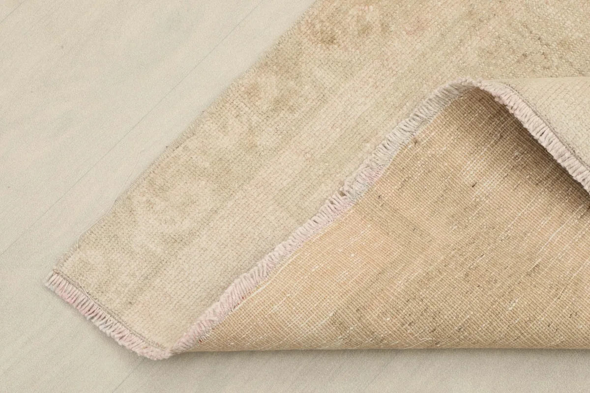 Corner of the runner folded back, revealing the wool pile on cotton foundation.