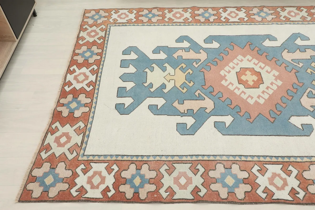 Angled perspective of the rug, showcasing the ivory field and colorful tribal motifs