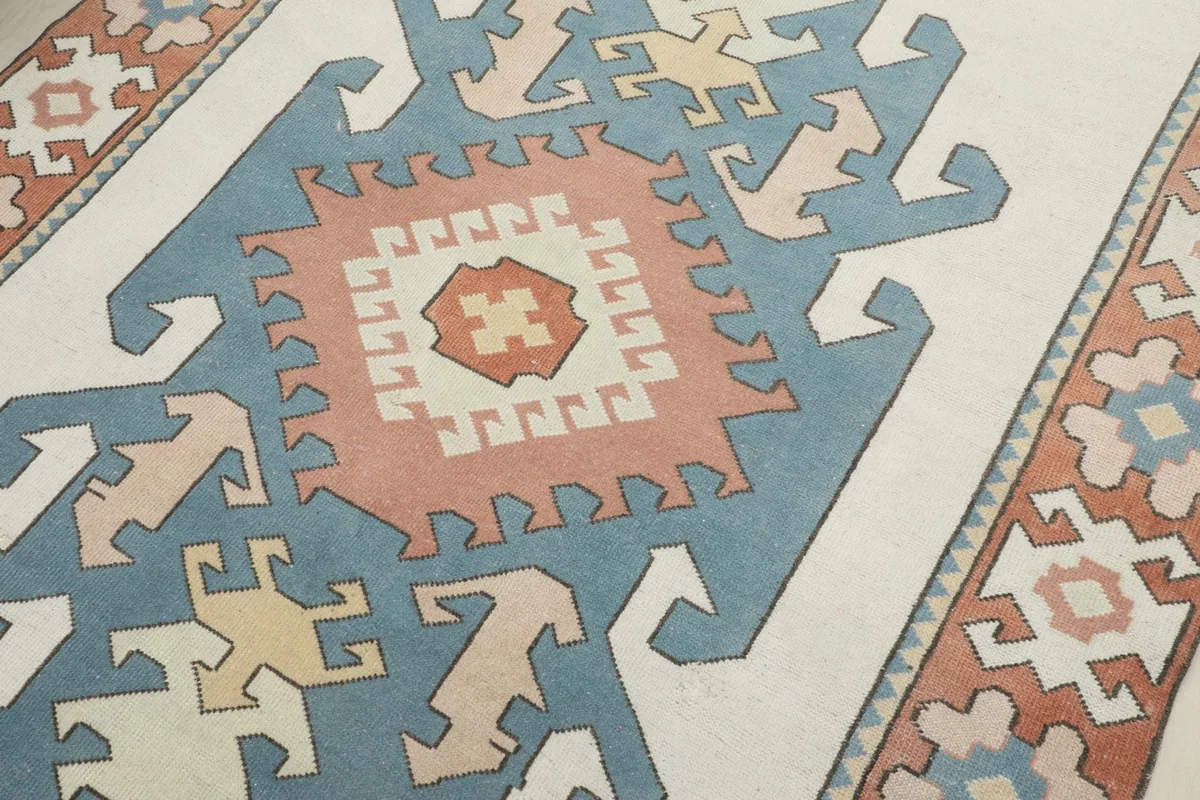 Close-up detail of the central tribal medallion in rust, blue, and ivory tones