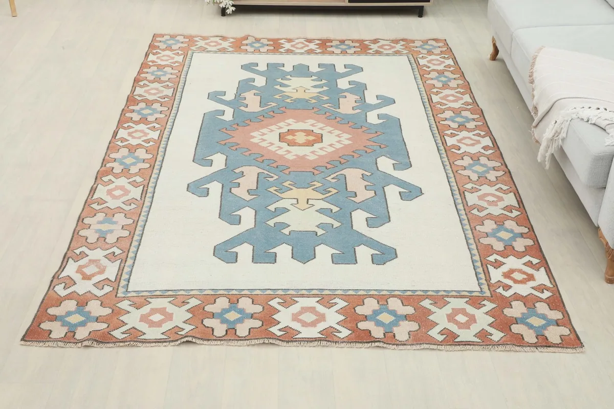 Overhead view of the vintage rug laid out in a room, showing its full design