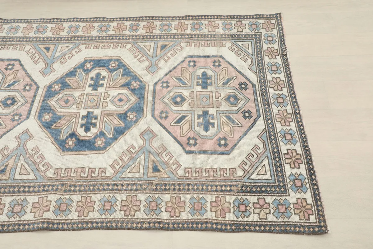 Close-up of the upper section of the rug, highlighting the geometric patterns and border design