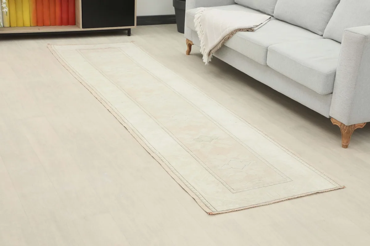 Angled view of the cream runner rug stretching across a room, highlighting its length and placement.