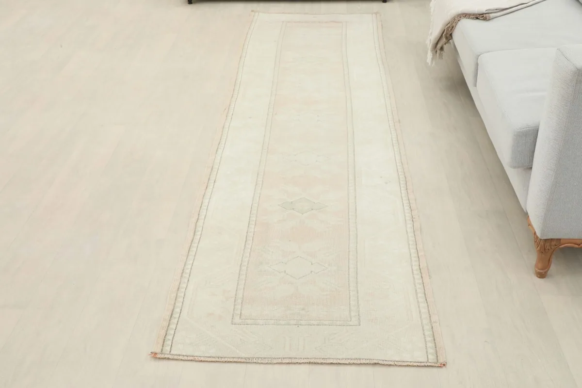 Full view of the cream runner rug in a room, providing a sense of its overall size and aesthetic.