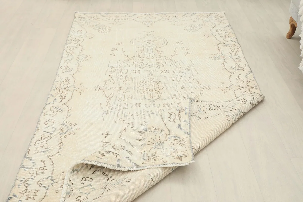 Rug with one corner folded, revealing the back of the hand-knotted construction