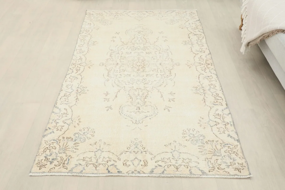 Overhead view of the cream medallion rug in a room, showing its full length