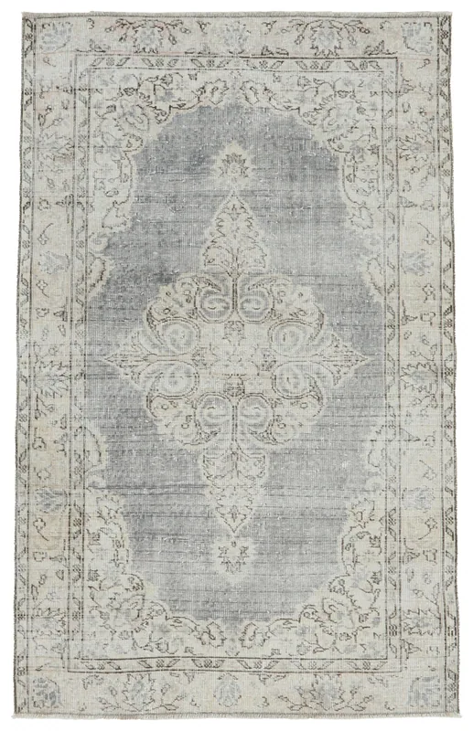 Full top view of the vintage Anatolian area rug with a gray blue field and ivory medallion