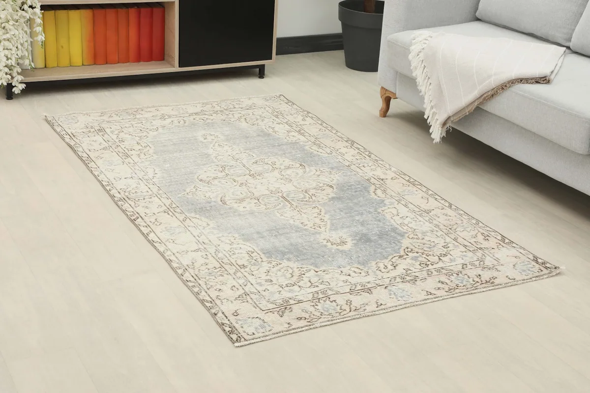 Angle view of the gray blue vintage rug on a light floor in a modern living space